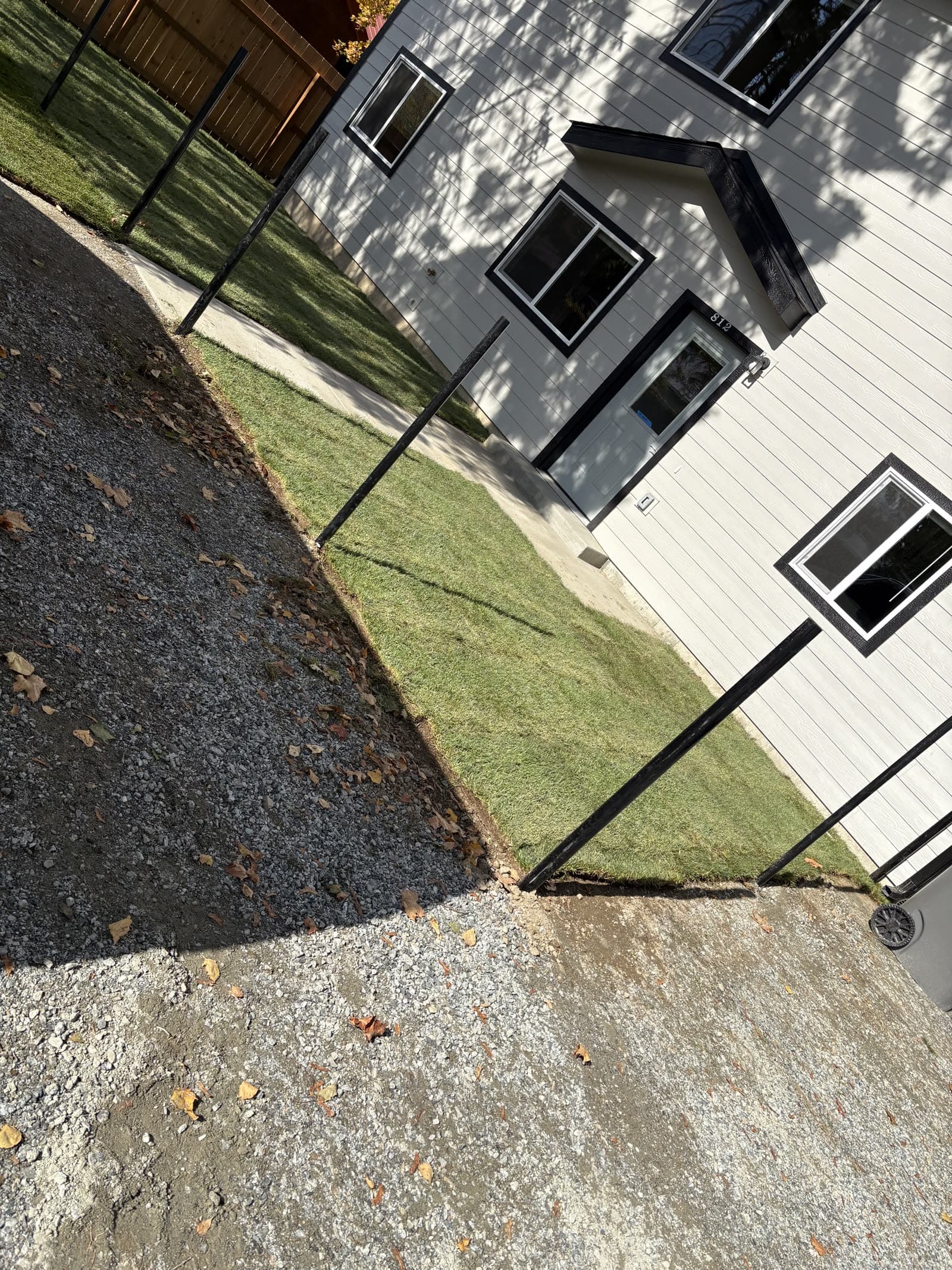 After: A new install at a white two-story home going from prepped soil to fresh-laid sod.