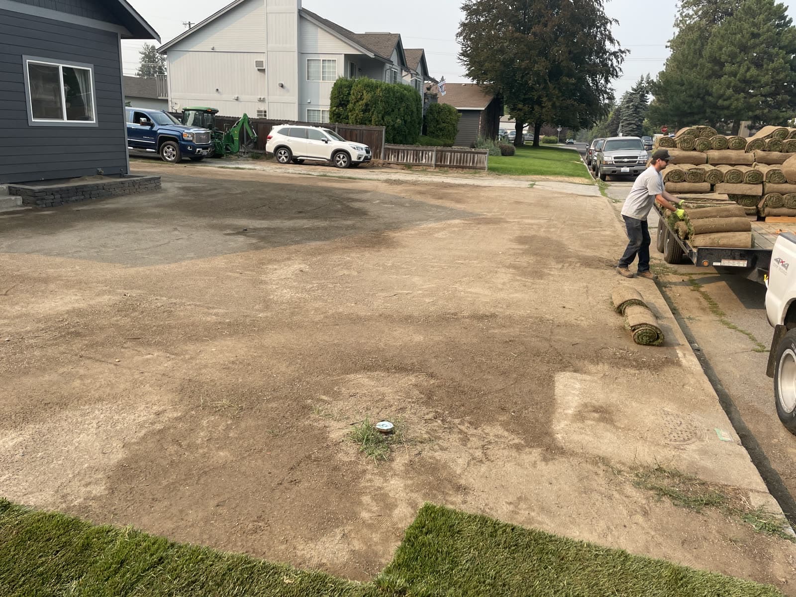 Before: A Spokane yard going from bare dirt with fresh-cut sod rolls delivered to a finished green lawn.